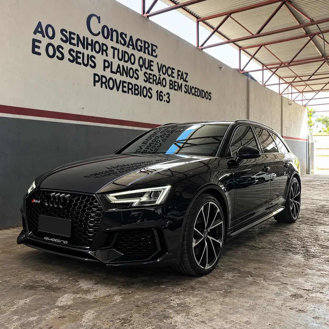 Carro preto fotografado em uma área interna da oficina